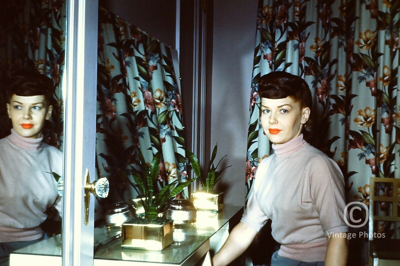 1950s American Fashion - Woman looking into mirror
